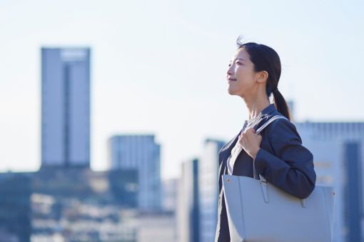 Japanese woman in front of large buildings